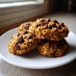 A stack of three homemade chocolate chip breakfast cookie on a white plate, ready to eat.
