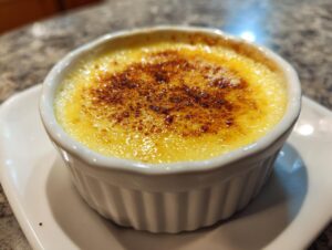 Close-up of a silky egg custard topped with a perfectly caramelized, dark brown sugar crust.