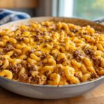 Close-up of a skillet filled with creamy, cheesy taco pasta mixed with seasoned ground beef.